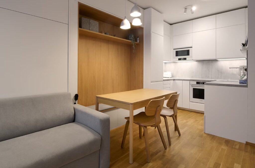 Symetrii kuchyně zdůrazňují linie zafrézovaných úchytek ve dvířkách a elegantní hluboký mat lakovaného povrchu.